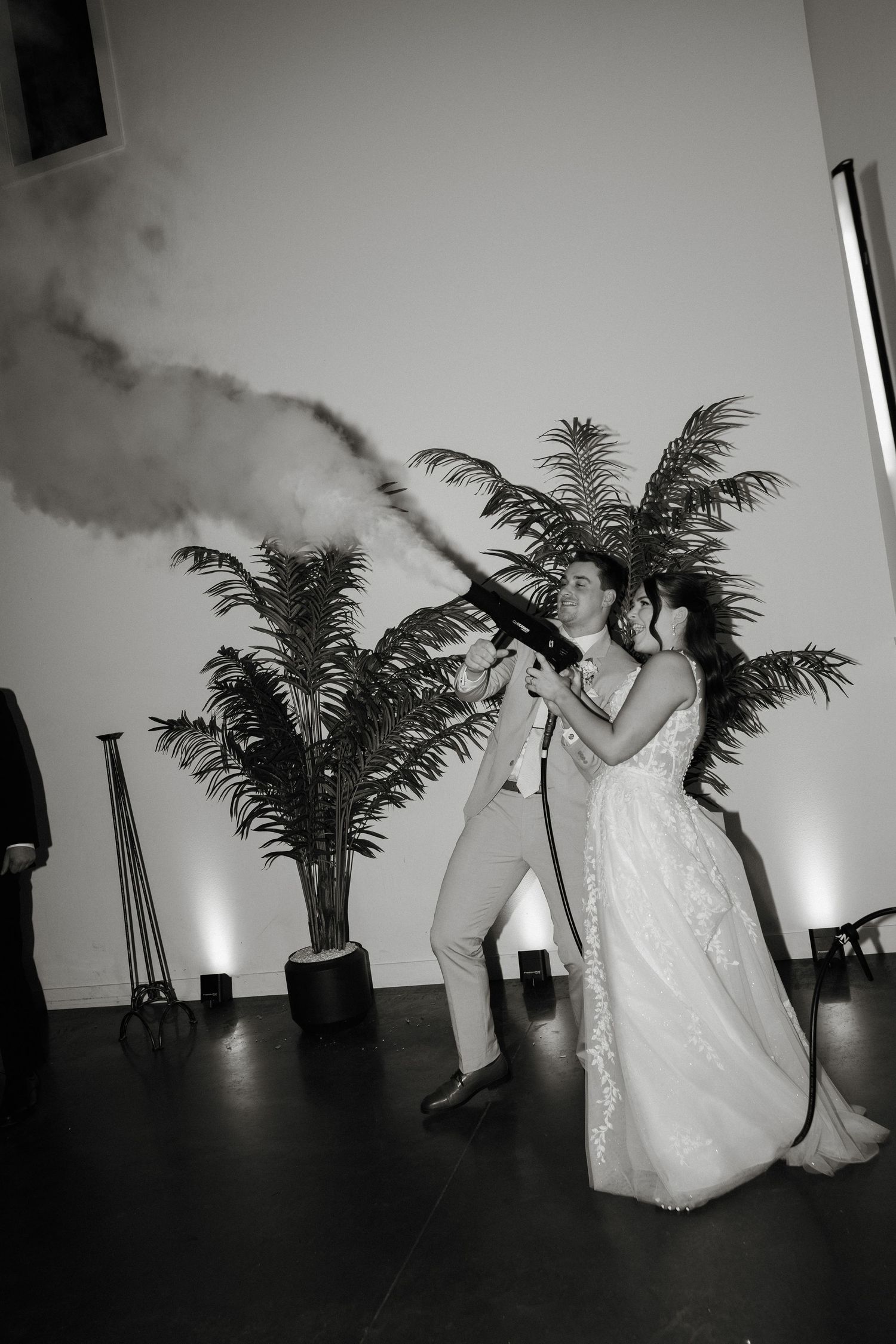 Black and white photo series showing a couple dancing in a room with a palm plant silhouetted against a light wall.