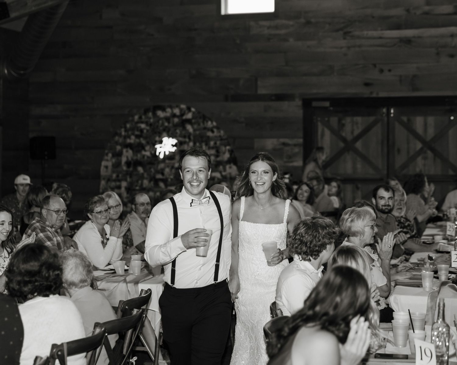 A black and white photo montage showing wedding reception scenes with dancing and celebrating guests at a rustic venue.
