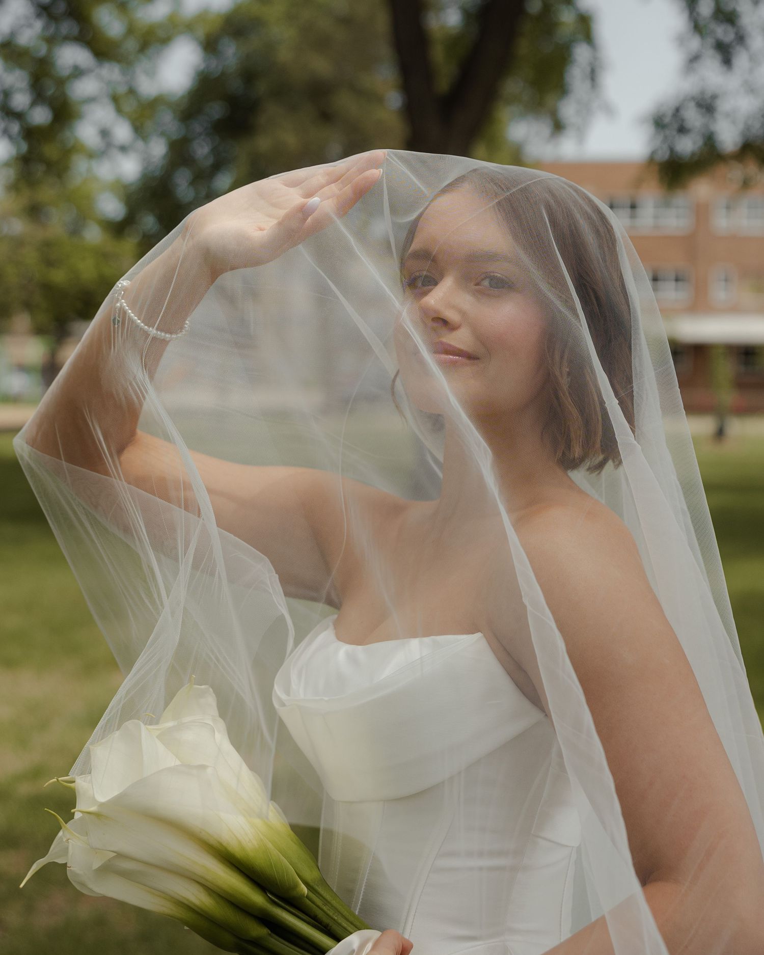 Artistic bridal portraits showing flowing veil and elegant white dress details outdoors.