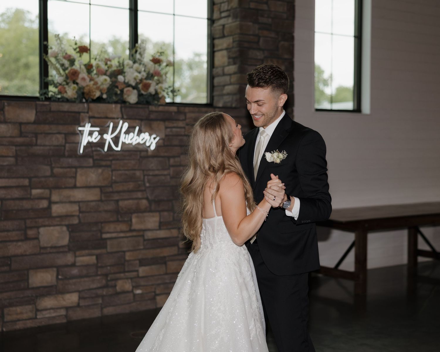 Wedding couple shares a private first look moment in front of a modern brick wall interior.