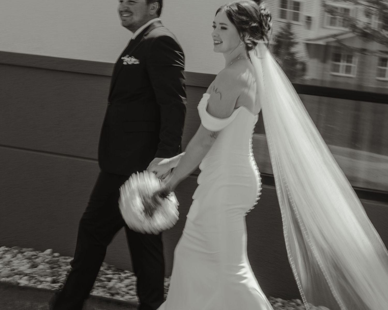 Black and white wedding photos show couple walking together in sequence with flowing white dress and veil.