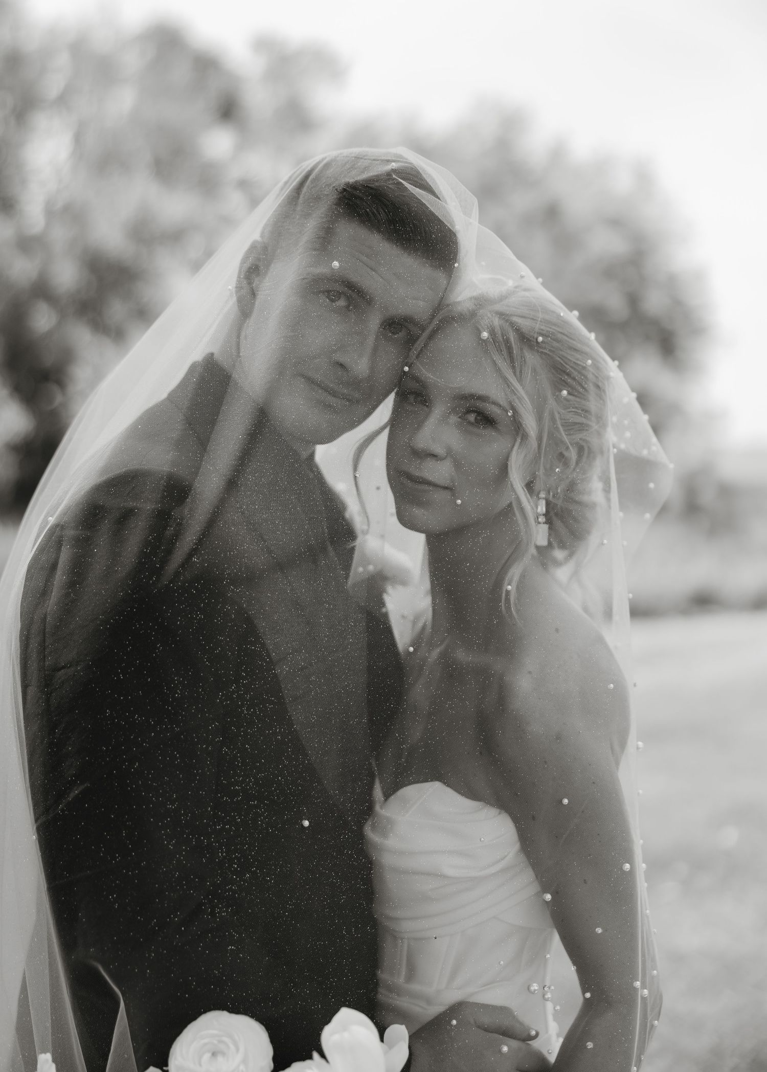 Black and white romantic wedding portrait series showing couple embracing outdoors in four different poses.