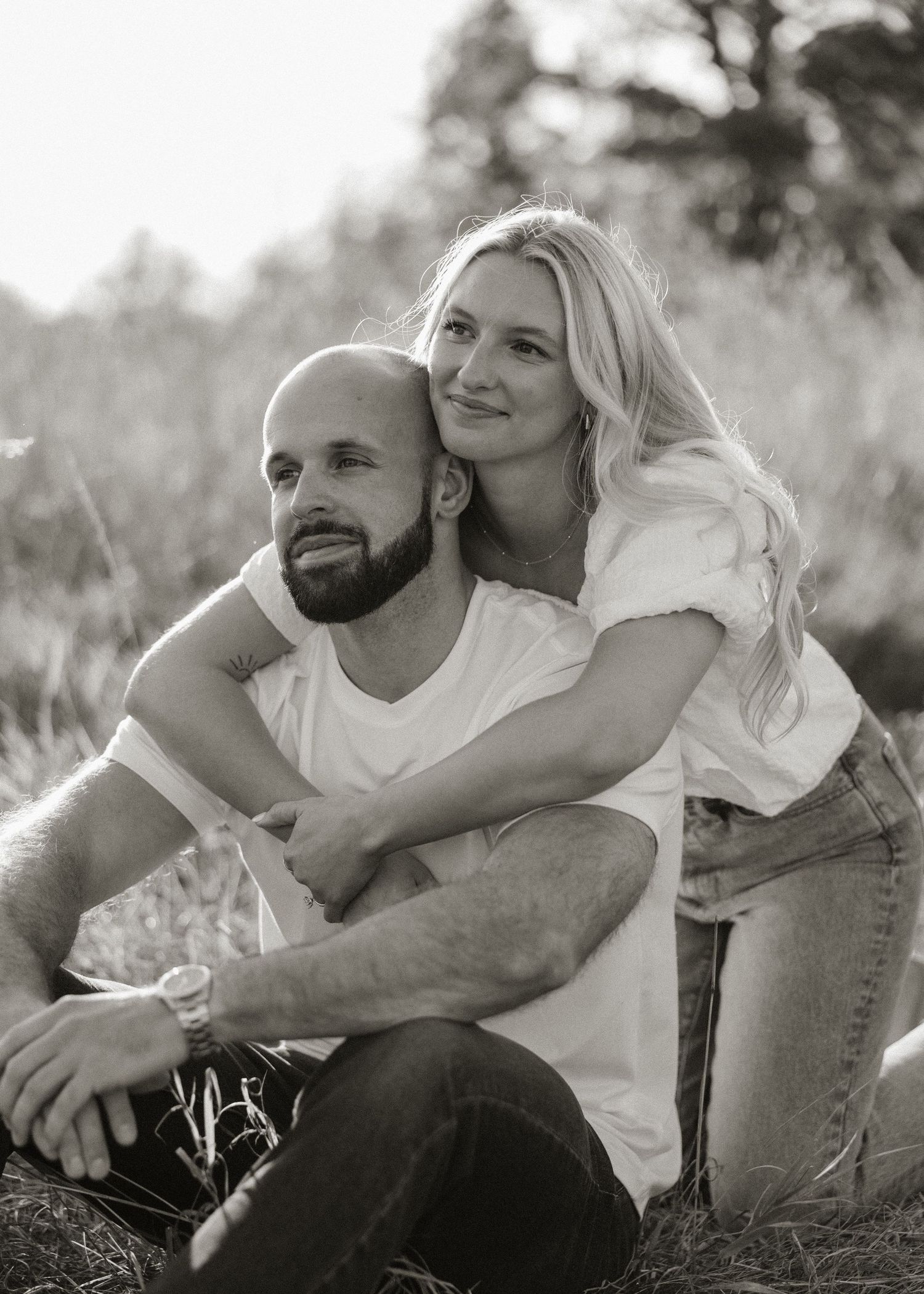 A couple embraces and shares intimate moments in a series of black and white outdoor photos.