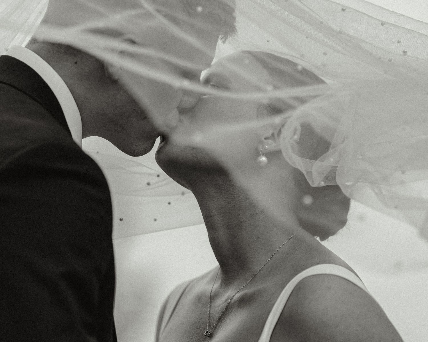 Ethereal wedding veil floating in the breeze during an intimate moment.