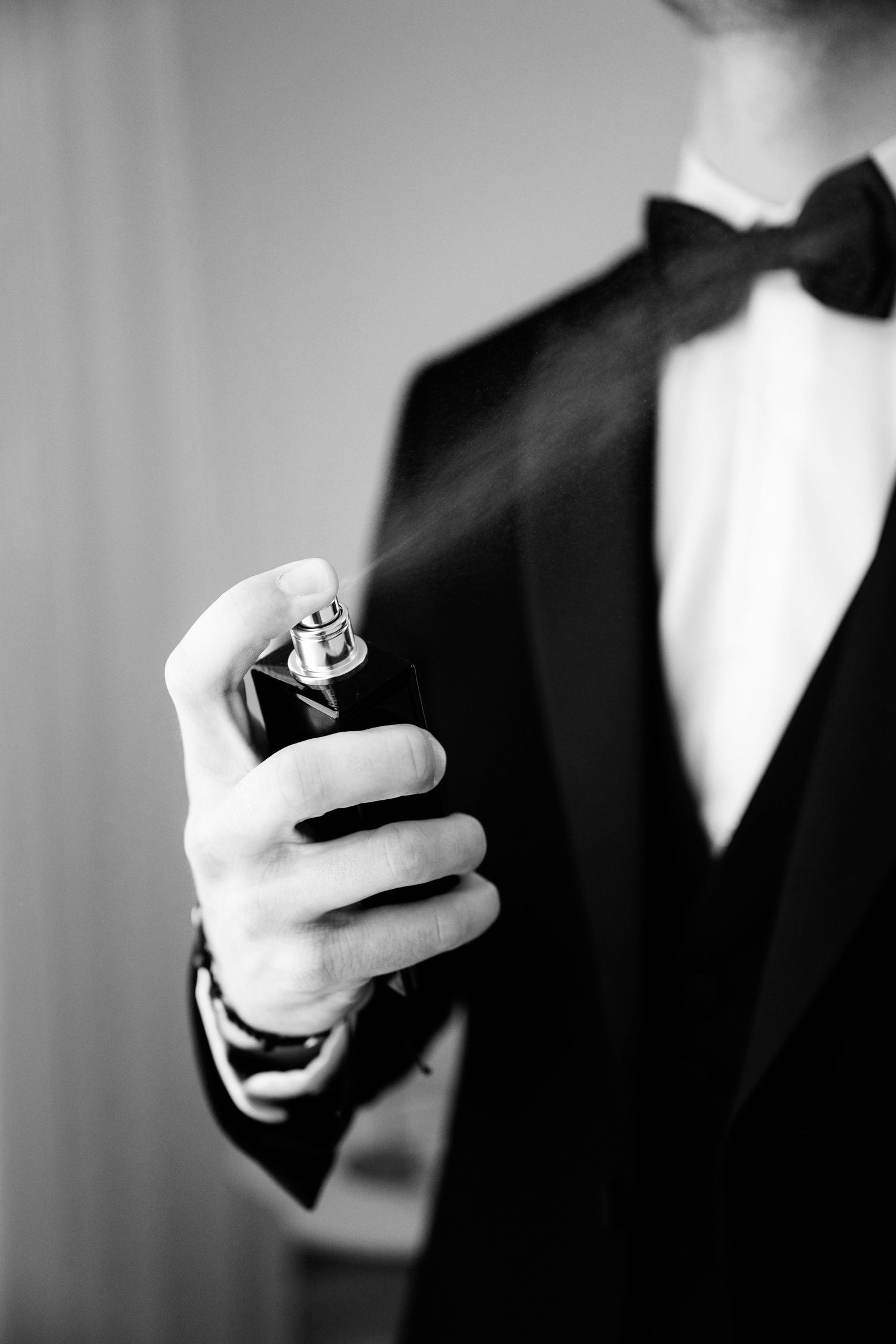 A series of black and white photos showing hands holding a ring in formal wedding attire.