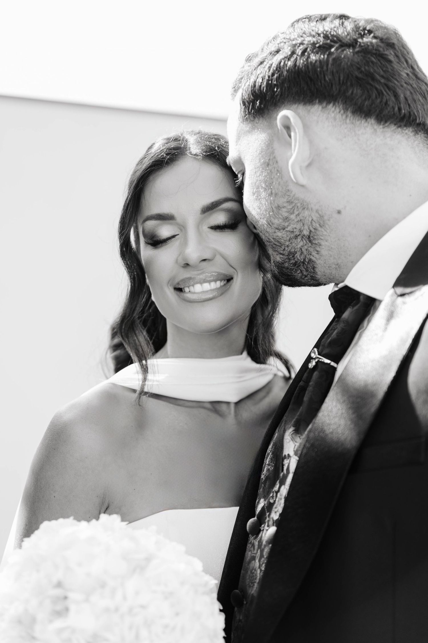 A romantic black and white wedding photo series showing tender moments between newlyweds during their celebration.