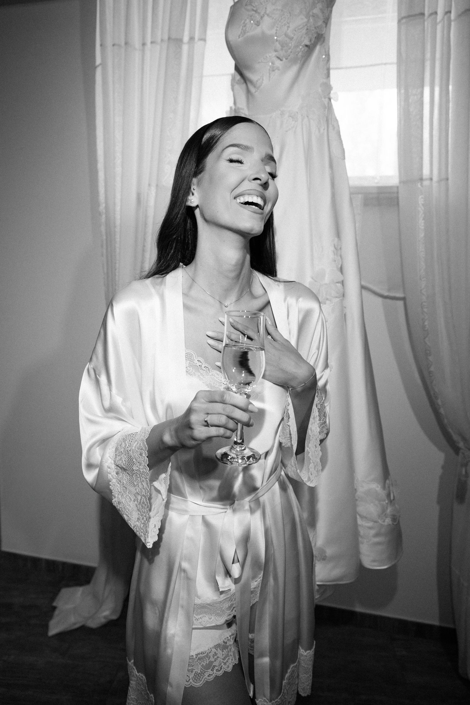A series of black and white photos showing a person in white clothing moving gracefully against sheer curtains.