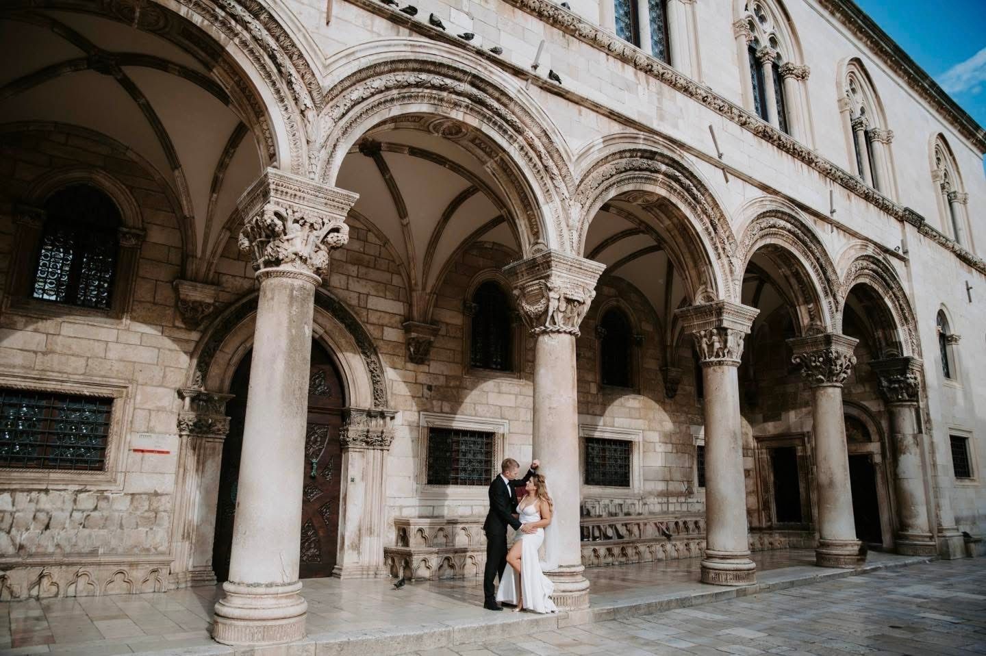 Elegant stone archways create a romantic setting with Mediterranean architecture for an intimate wedding moment.