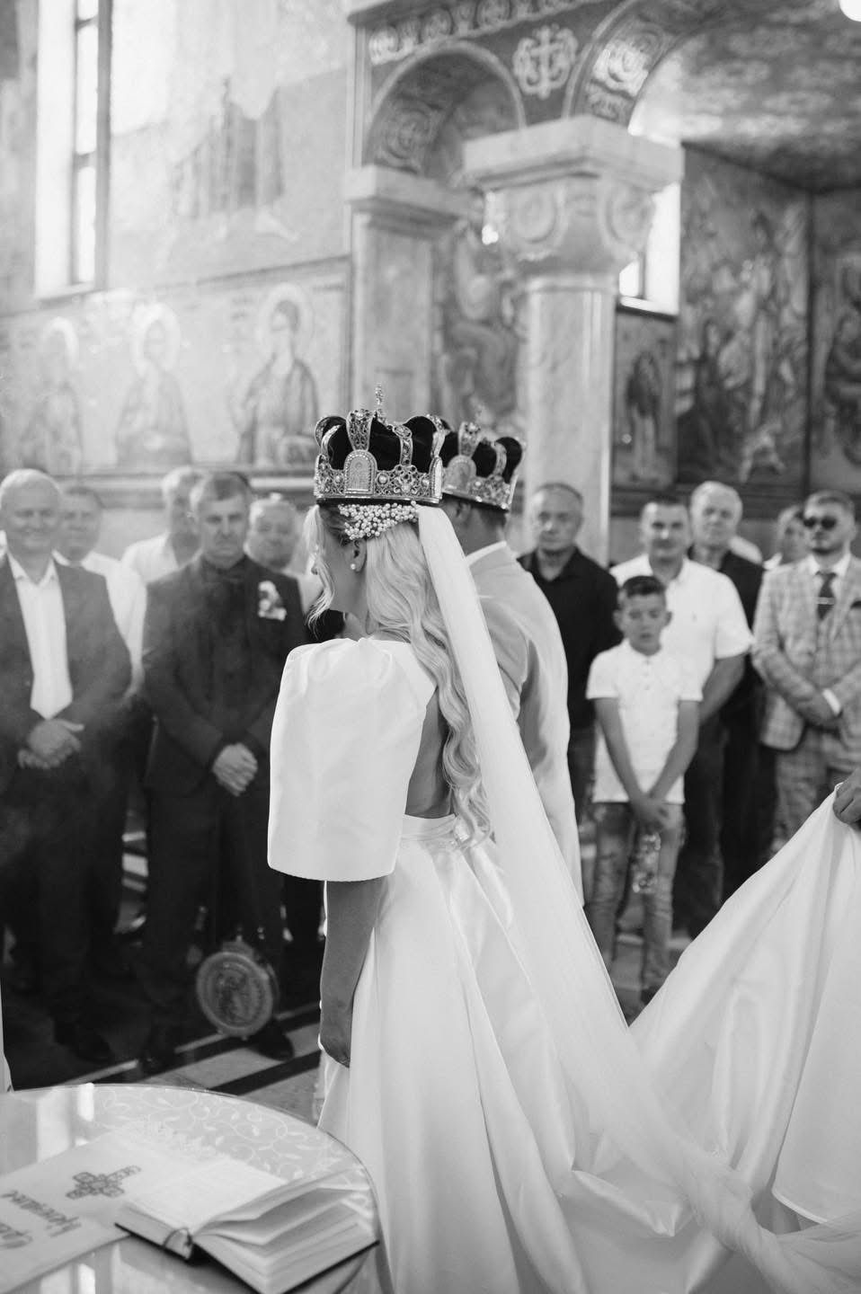 A black and white photo of a wedding ceremony in a historic church interior.