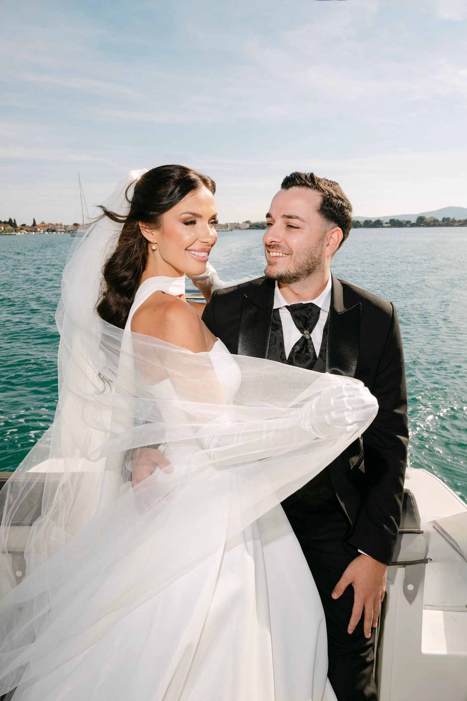 A romantic wedding photoshoot on a boat with flowing veil catching the ocean breeze.