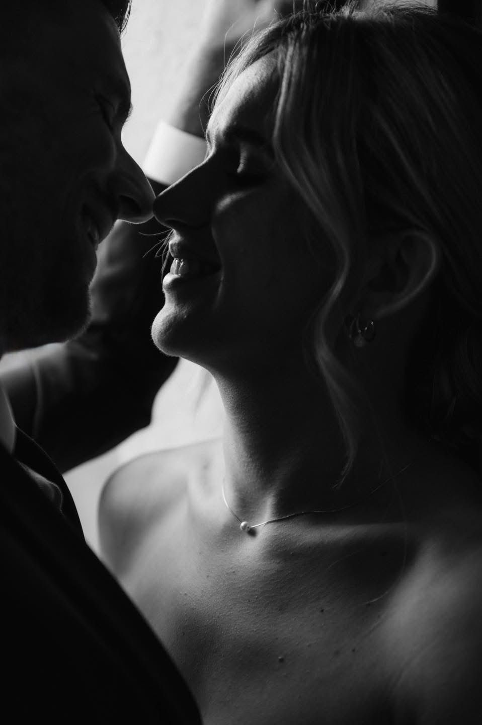 An intimate black and white close-up of a tender moment between newlyweds.