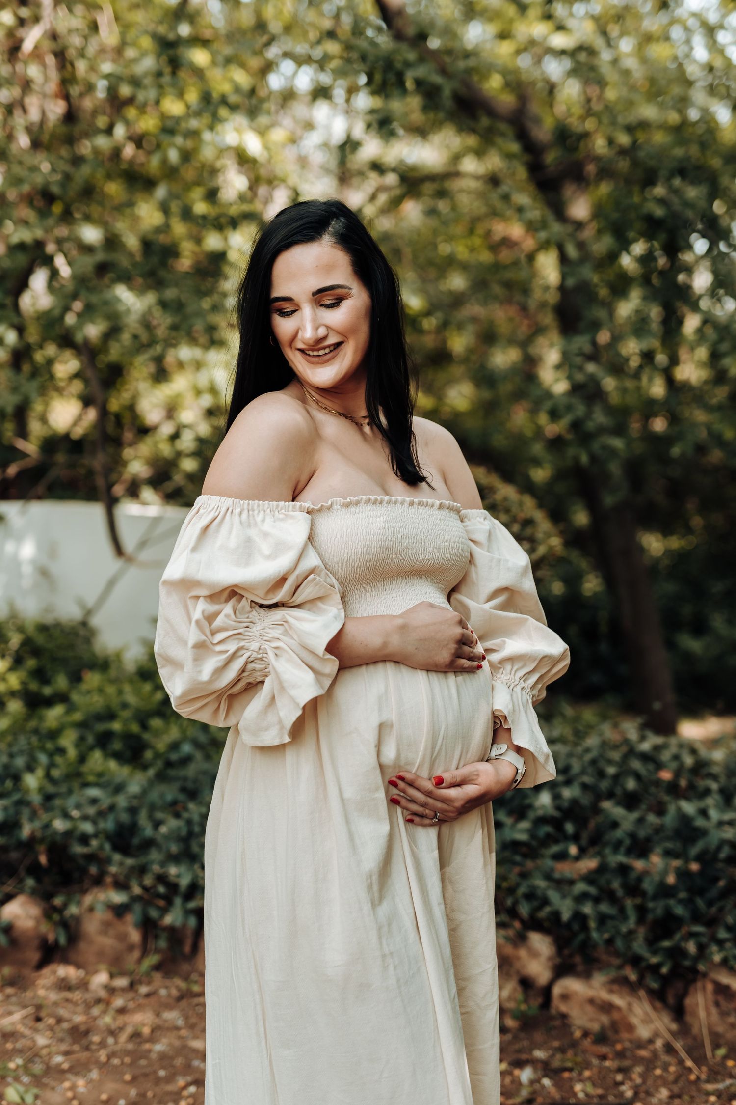 A series of outdoor maternity photos showing a woman in a cream-colored off-shoulder dress against a natural garden backdrop.