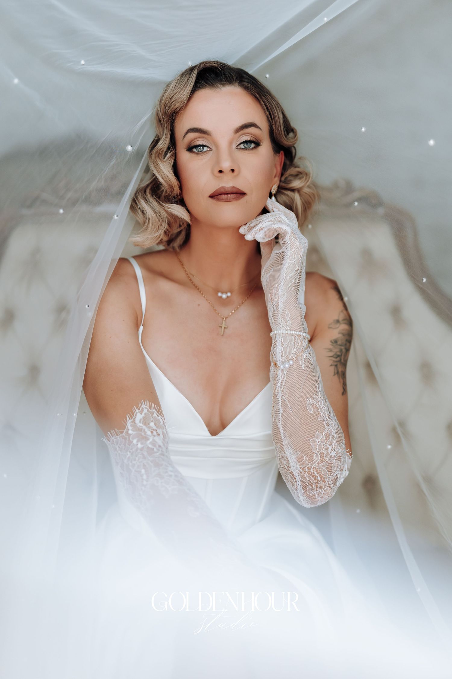 Dreamy bridal boudoir photos with soft white lace and romantic lighting.