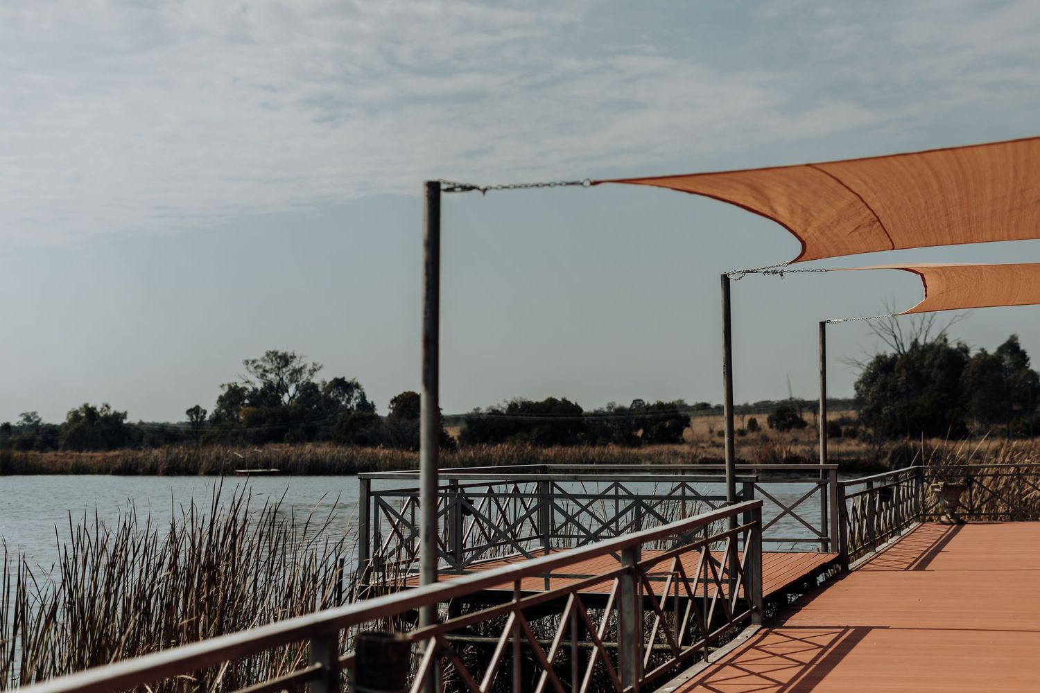 A large terrace railing extends along the edge of a stone patio overlooking the countryside.