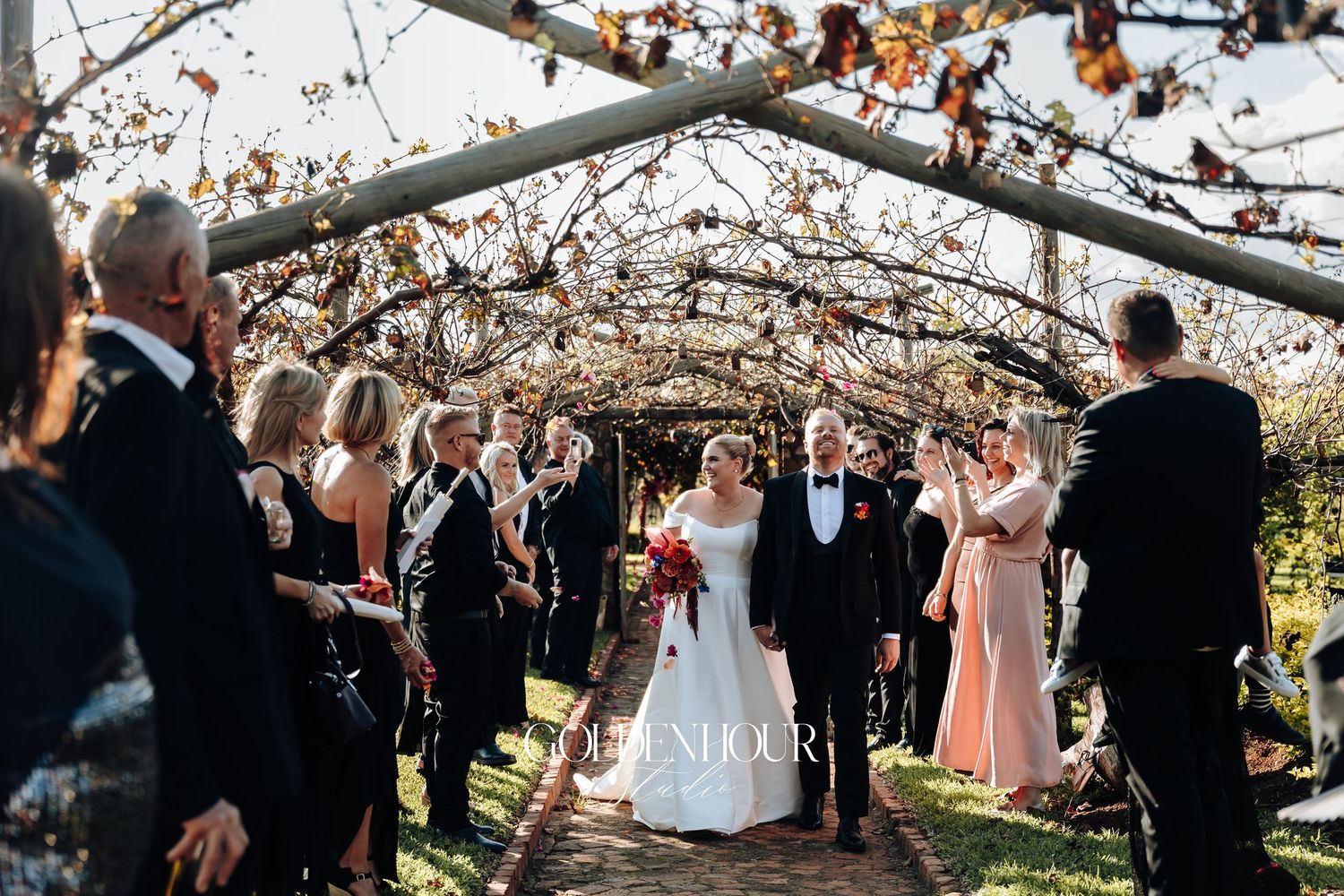 Wedding ceremony takes place under blooming cherry blossom trees with guests gathered around in springtime.