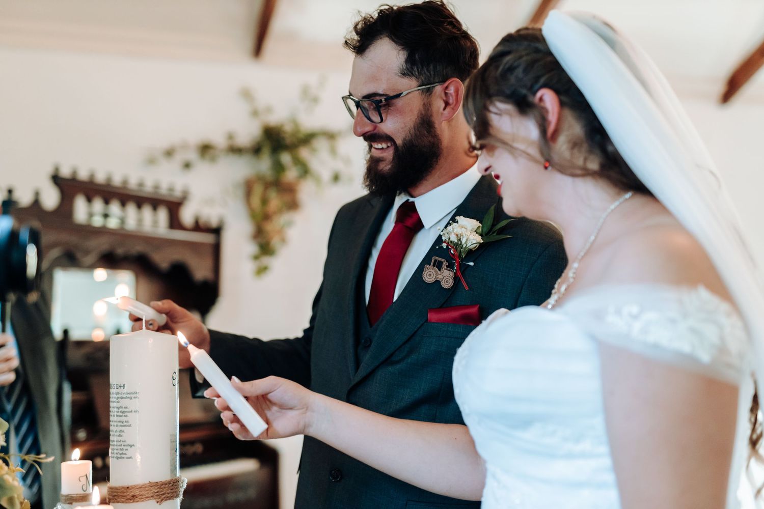 Wedding couple participating in a unity candle ceremony with decorative white candles.