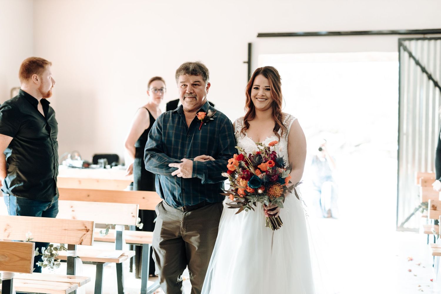 Wedding ceremony processional in minimalist indoor venue with natural lighting.