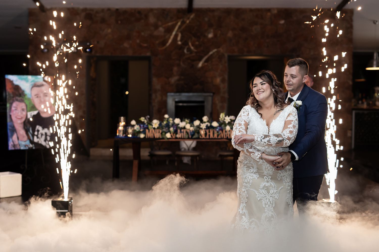 Newlyweds share first dance surrounded by low-lying fog and sparkler fountains.