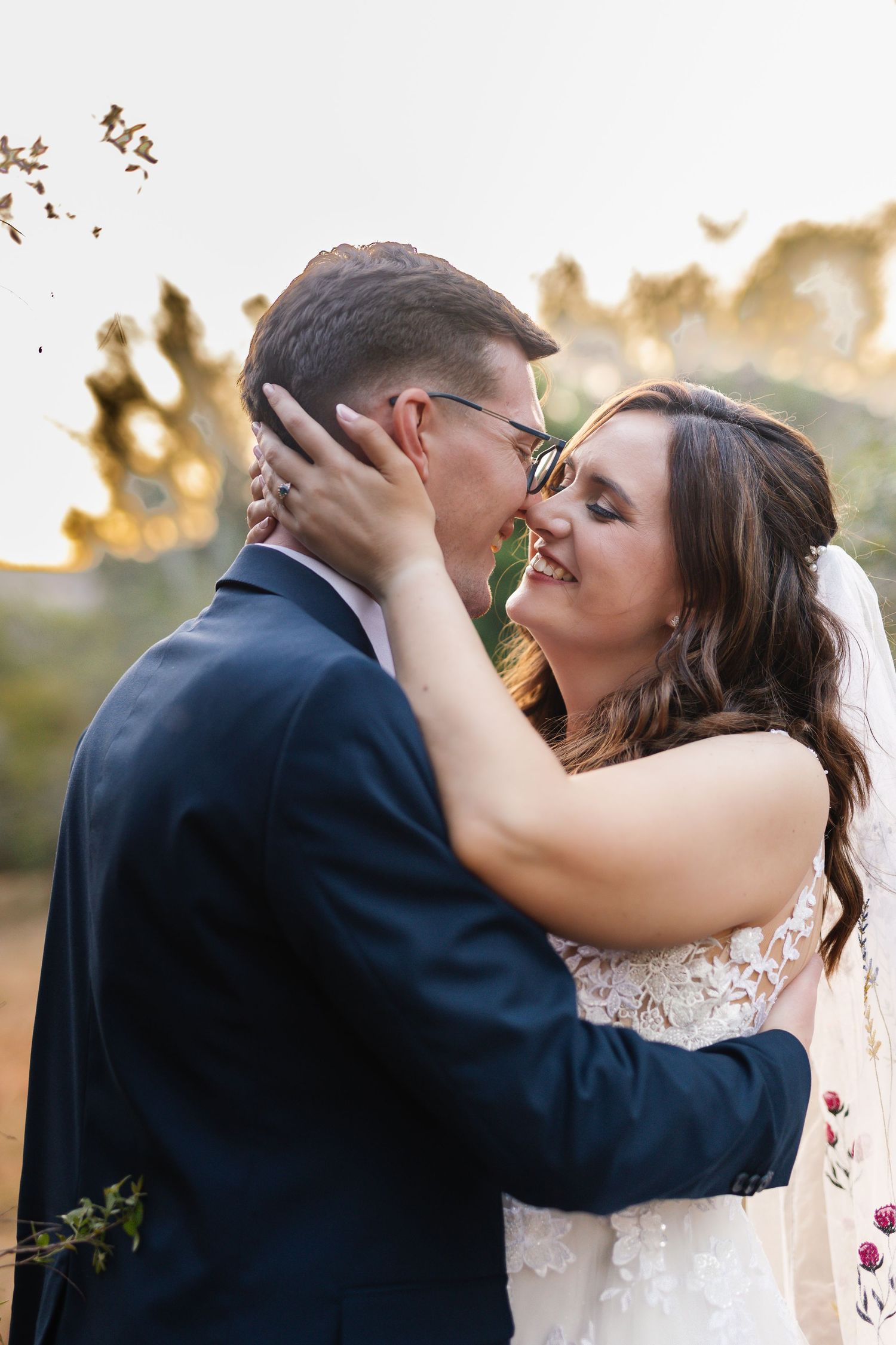A romantic wedding couple shares intimate kisses in a series of sunset portraits outdoors.