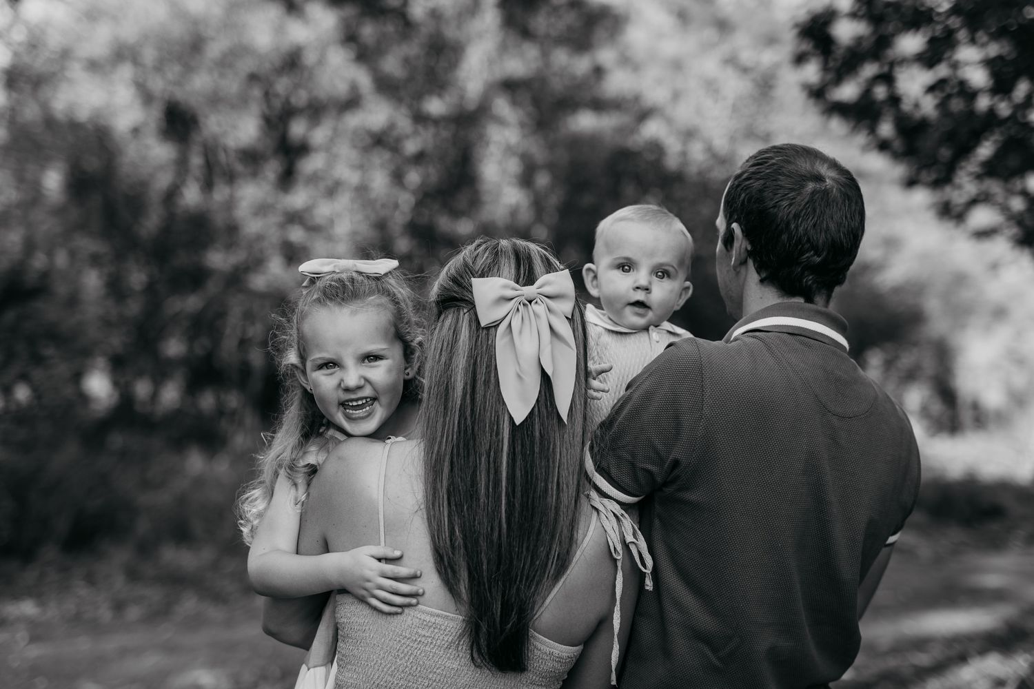 A cheerful family enjoys candid moments together during a golden hour outdoor photo session.