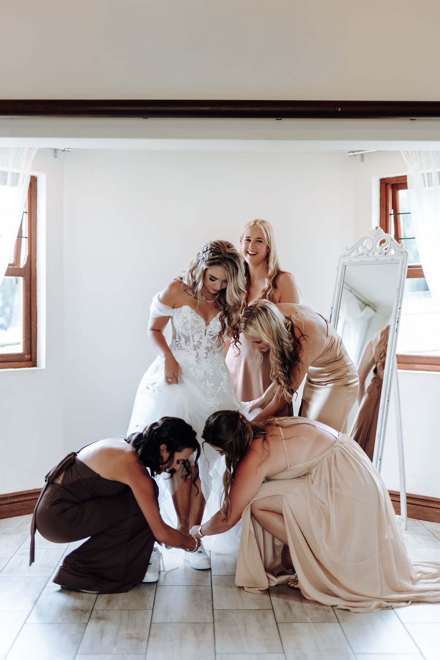 A sequence of artistic black and white wedding photos showing tender moments between a bride and her dog on the floor.