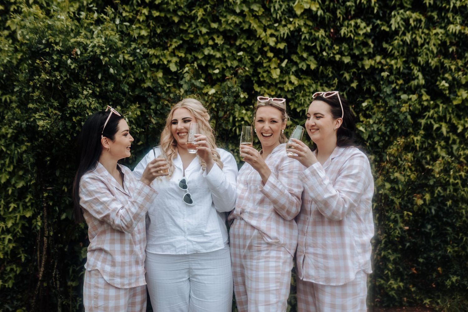 A group in matching sleepwear shares laughter while celebrating outdoors.