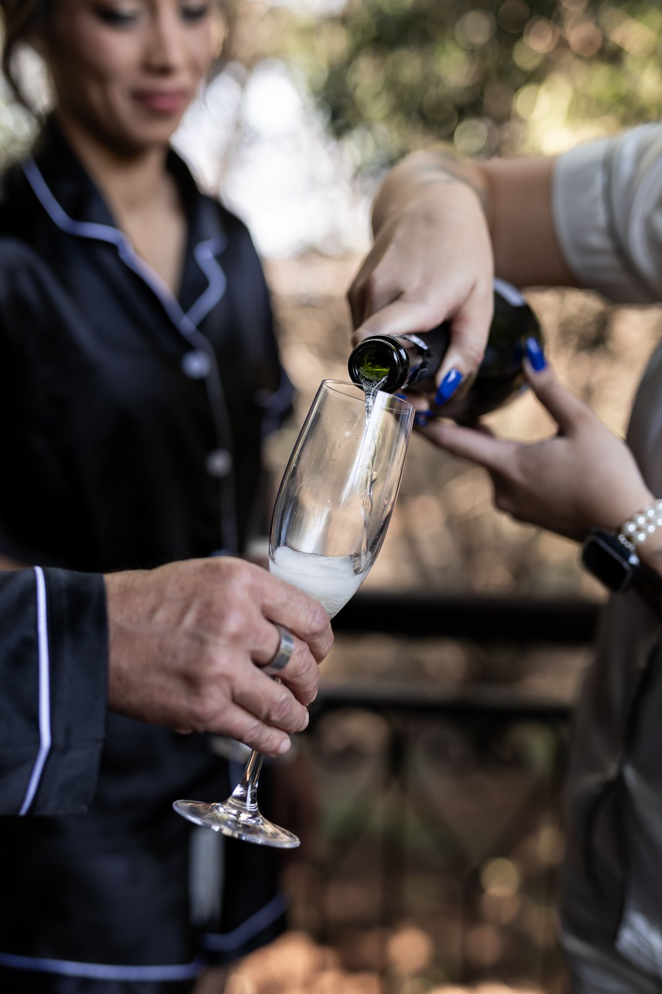 Champagne being poured into glass during wedding preparation.