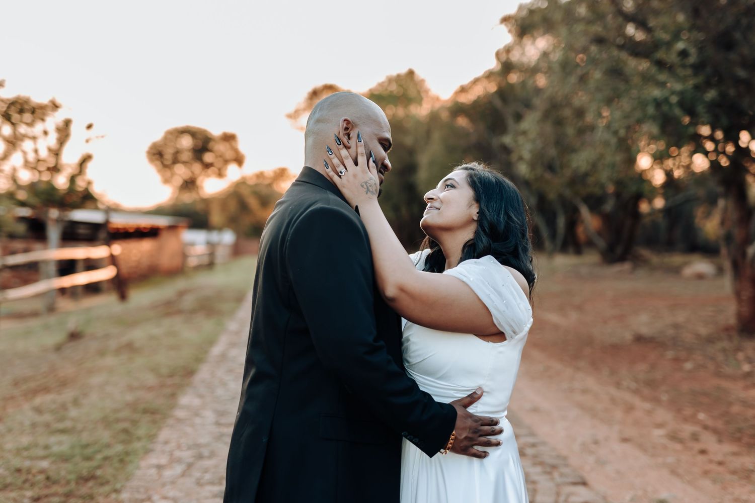 Emotional wedding moment captured between couple during outdoor sunset photoshoot.