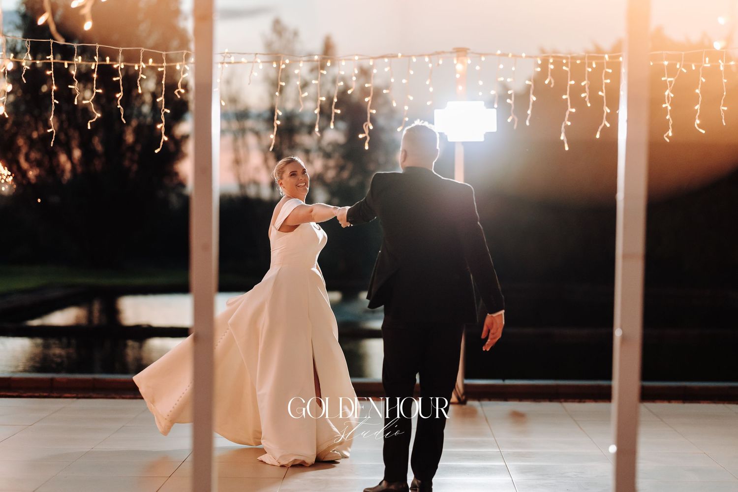 Romantic first dance at an evening wedding reception with warm glowing lights creating a dreamy atmosphere.