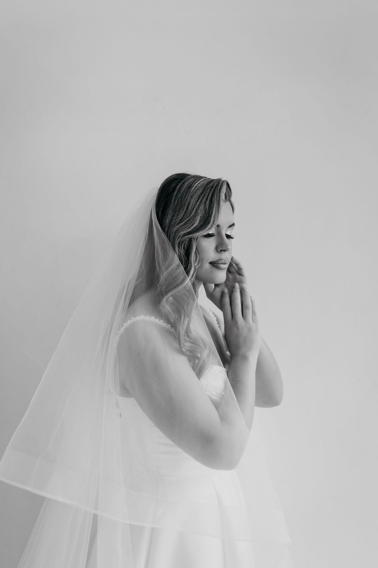 Emotional bridal portraits in black and white with flowing veil.