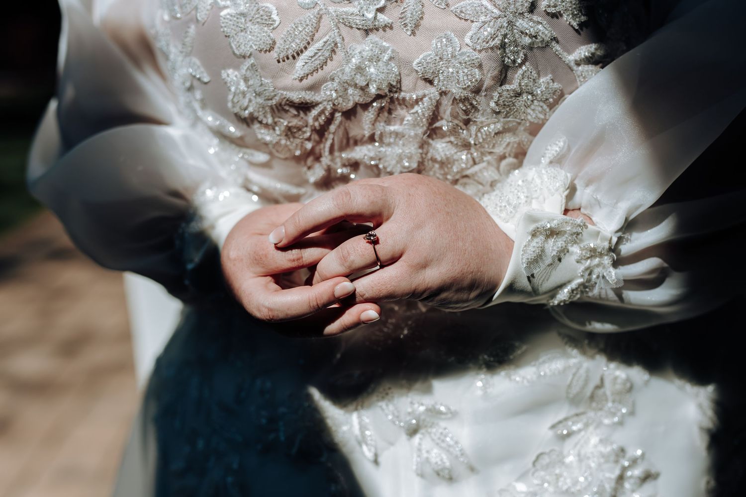 Close-up view of hands exchanging wedding rings during an elegant marriage ceremony.