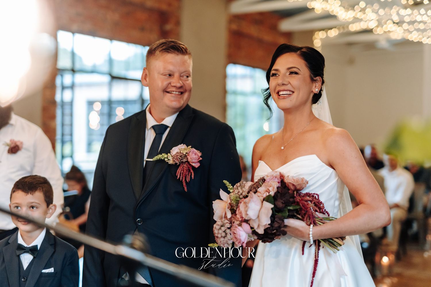 Happy bride and groom walking down the aisle together during their wedding ceremony with guests seated behind.