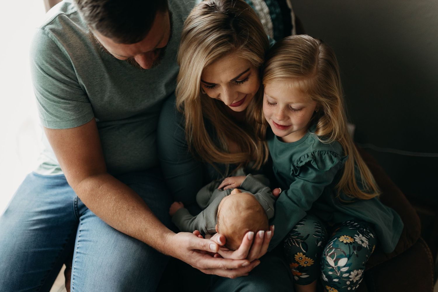 Parents sharing sweet moments of connection with their young child during an intimate indoor family photoshoot.