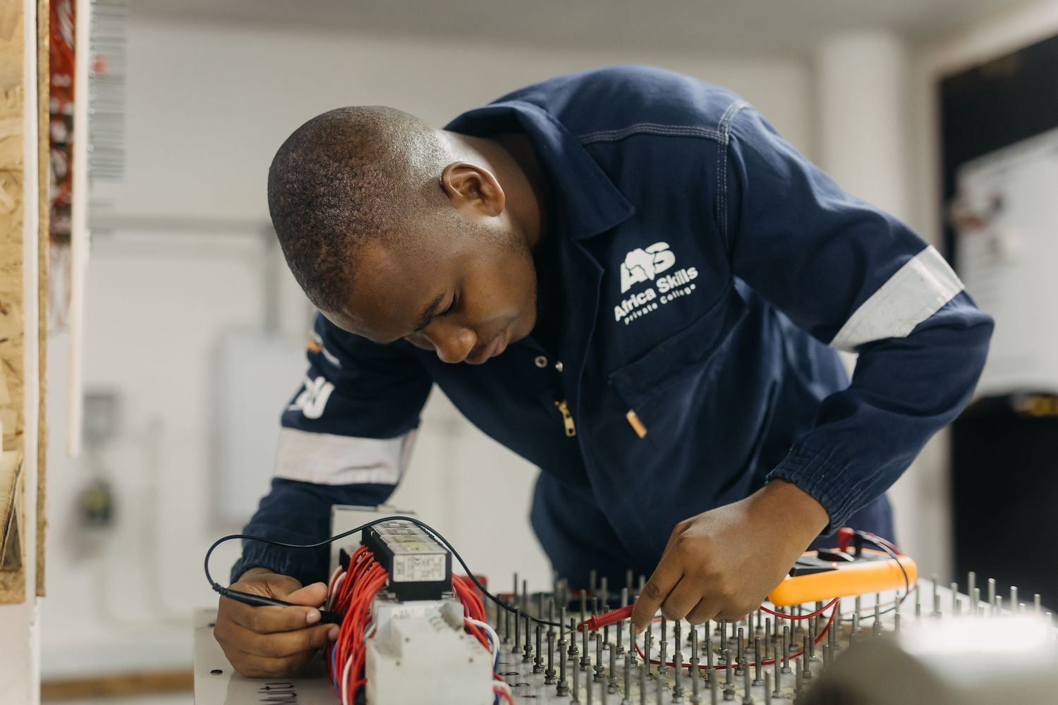 Person in safety gear examining equipment on an industrial manufacturing line.