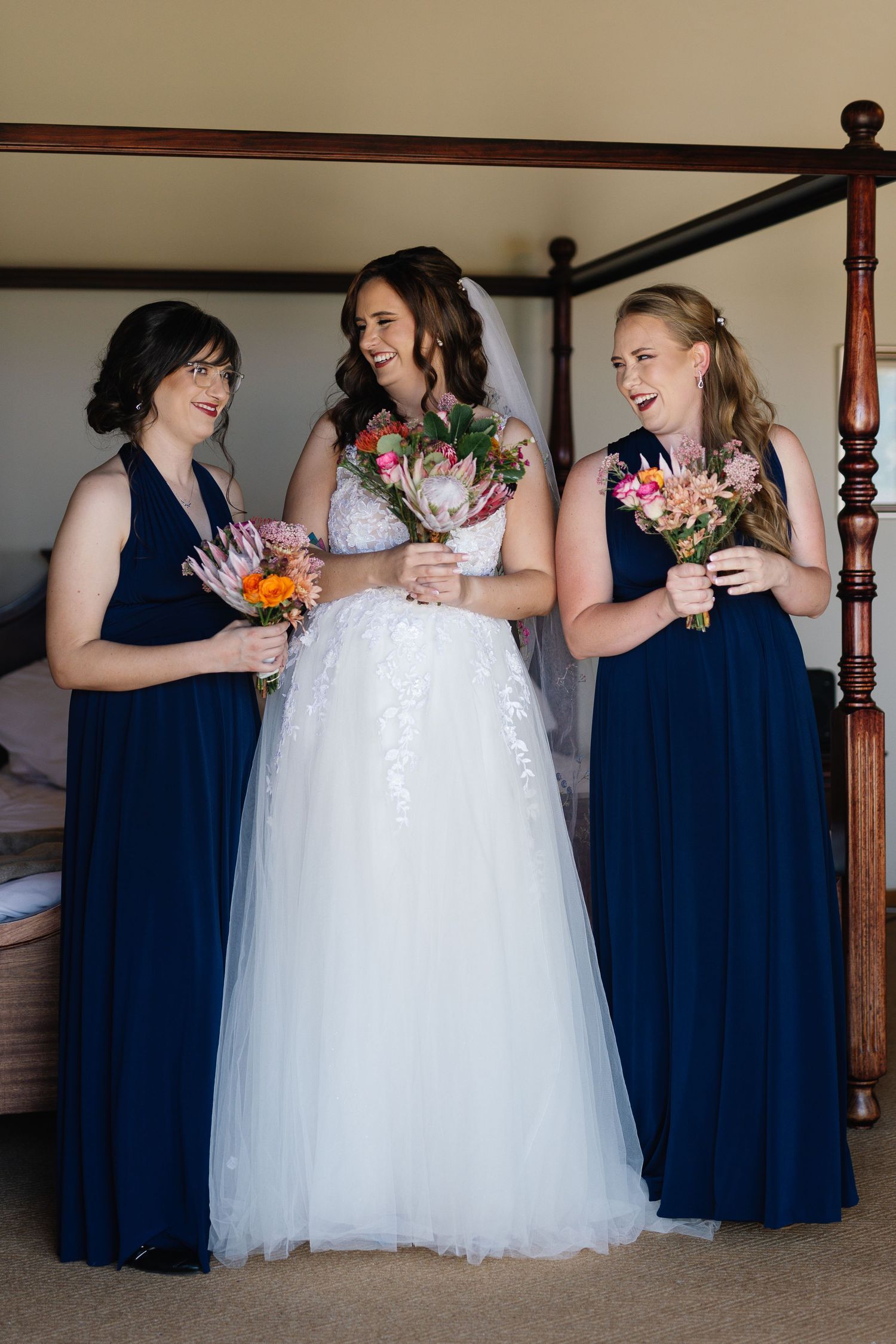 A sequence of wedding photos showing bridesmaids in navy dresses embracing the bride in a white tulle gown.