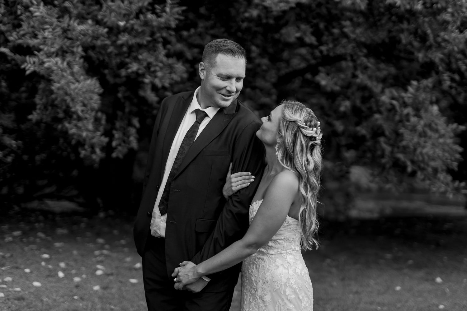 Black and white candid portrait of couple sharing joyful moment during wedding.