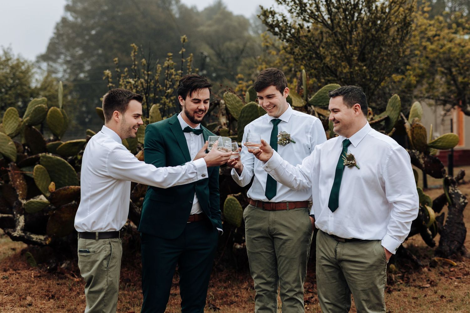 Wedding party raises glasses for a celebratory toast in an outdoor setting.