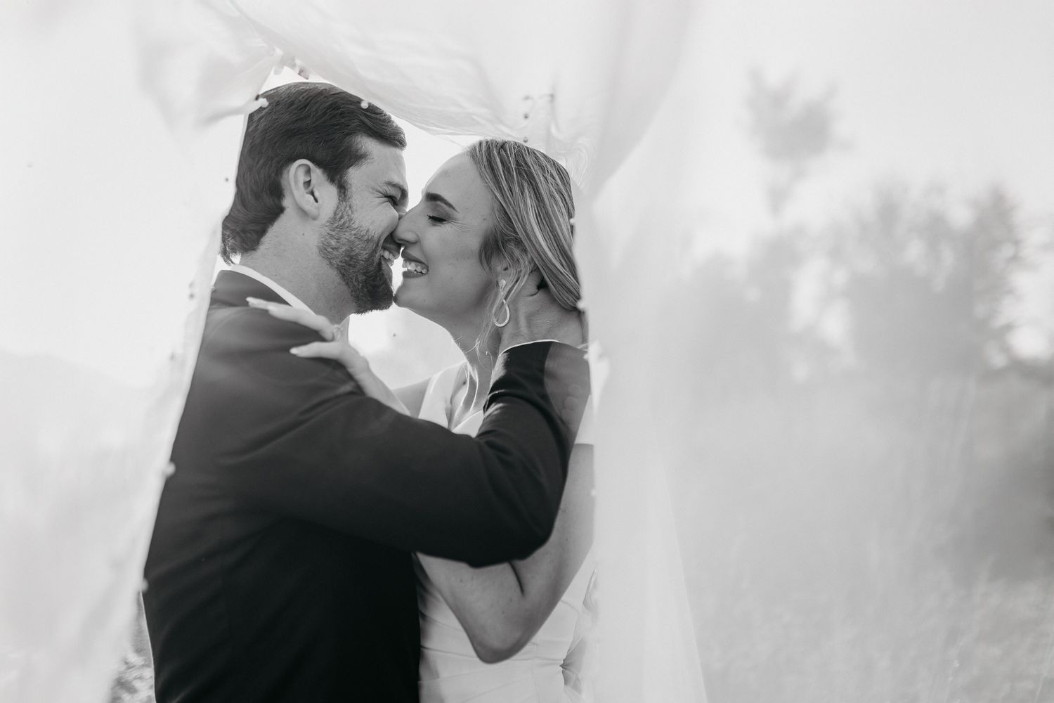 Black and white wedding portrait capturing an intimate moment between newlyweds.