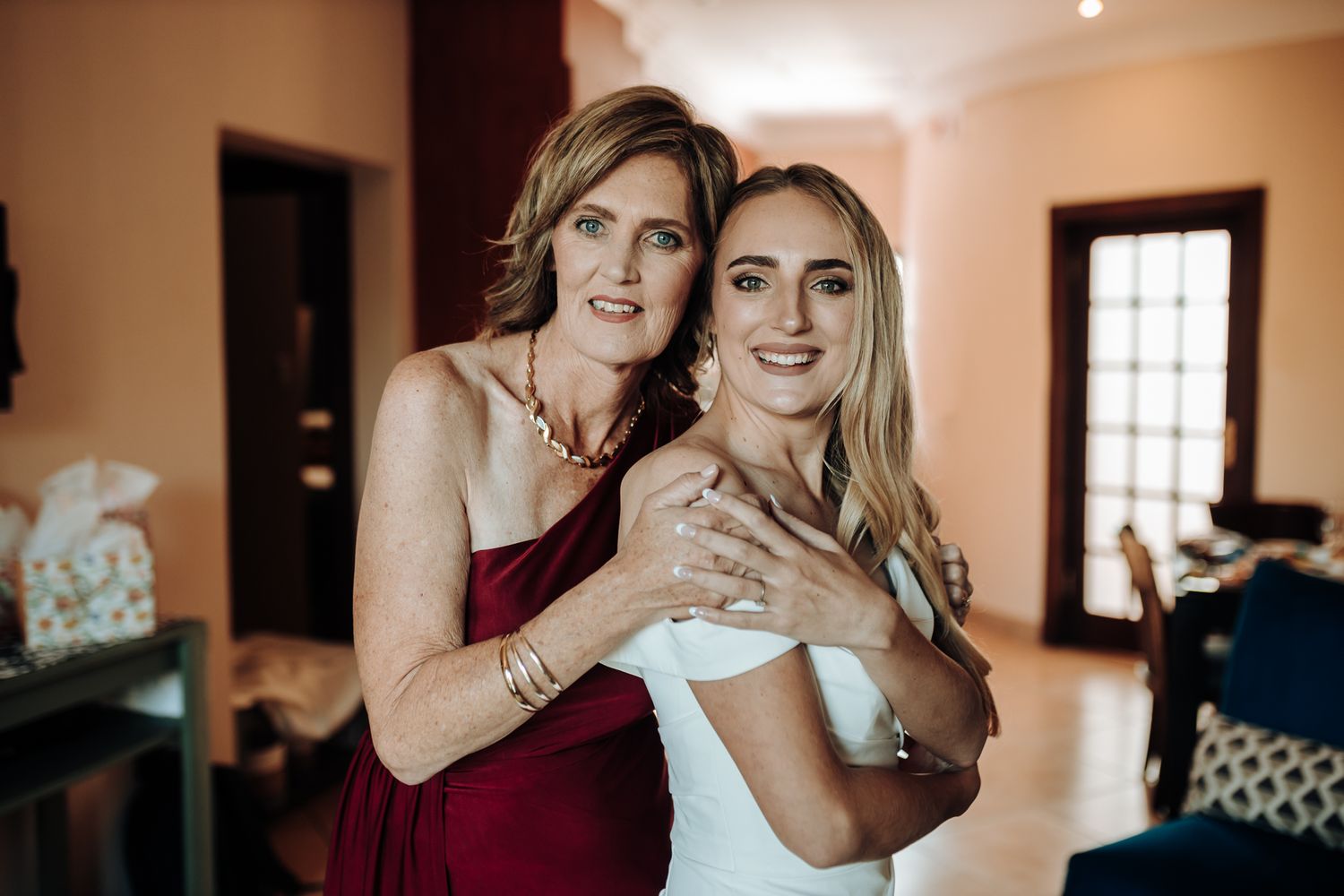 Emotional wedding day embrace captured in warm indoor lighting.