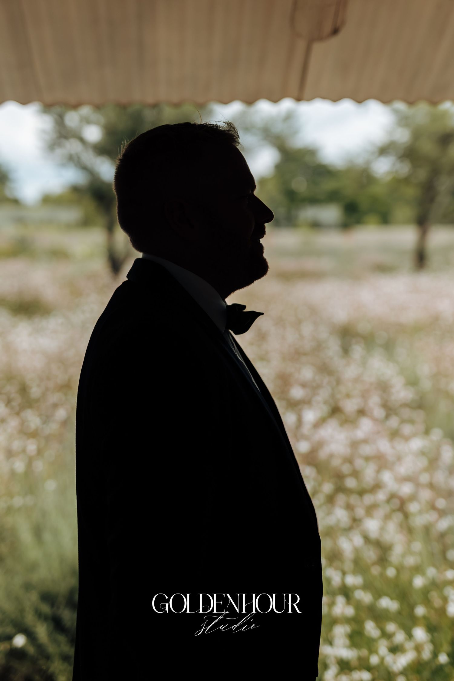 A silhouetted figure stands in a field of white wildflowers on a sunny day with Golden Hour text overlay.