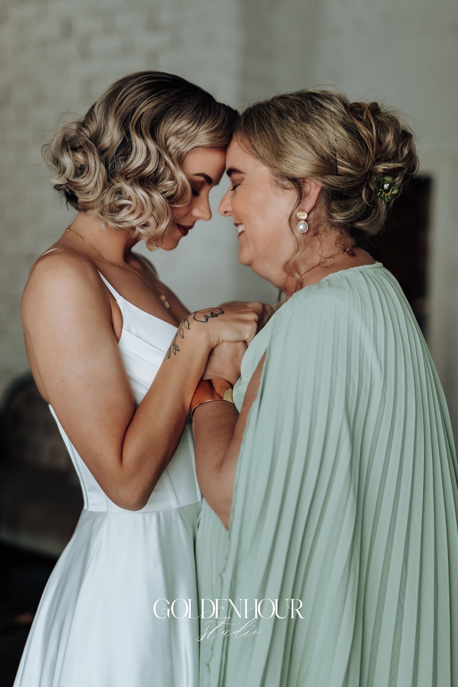 Intimate moment captured between two people in white and mint green formal attire.
