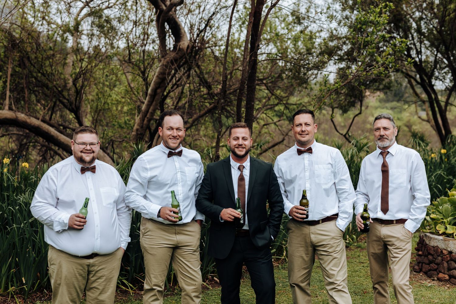A series of candid wedding party photos taken outdoors in a natural garden setting with trees and greenery.