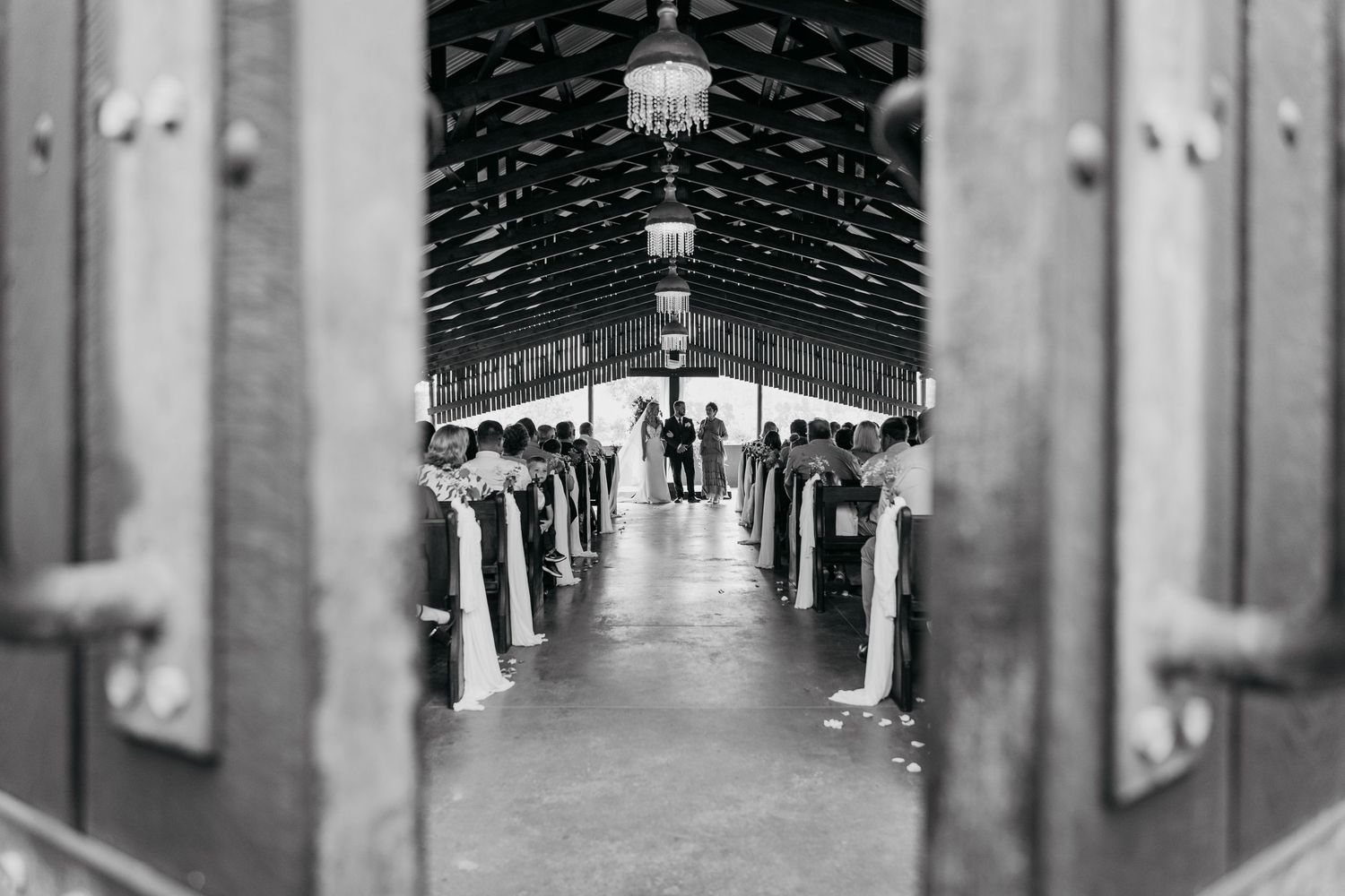 Long symmetrical corridor with white columns and arched ceiling in historic building interior.