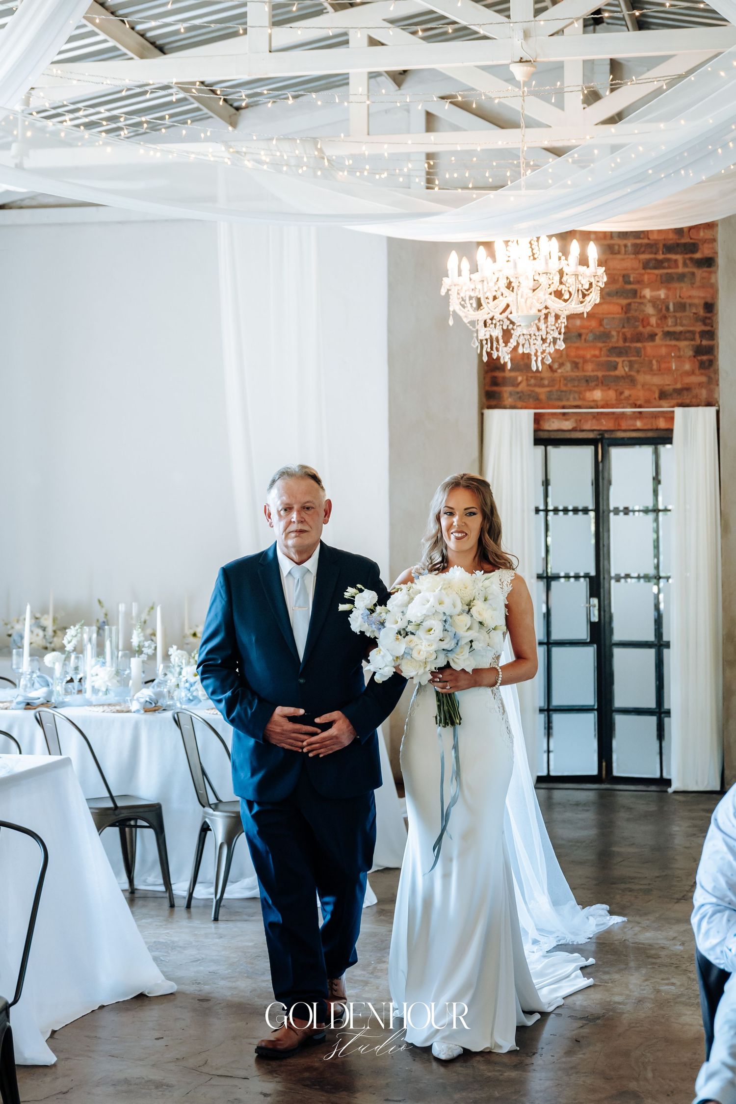 Elegant wedding reception venue with crystal chandeliers and white table settings.