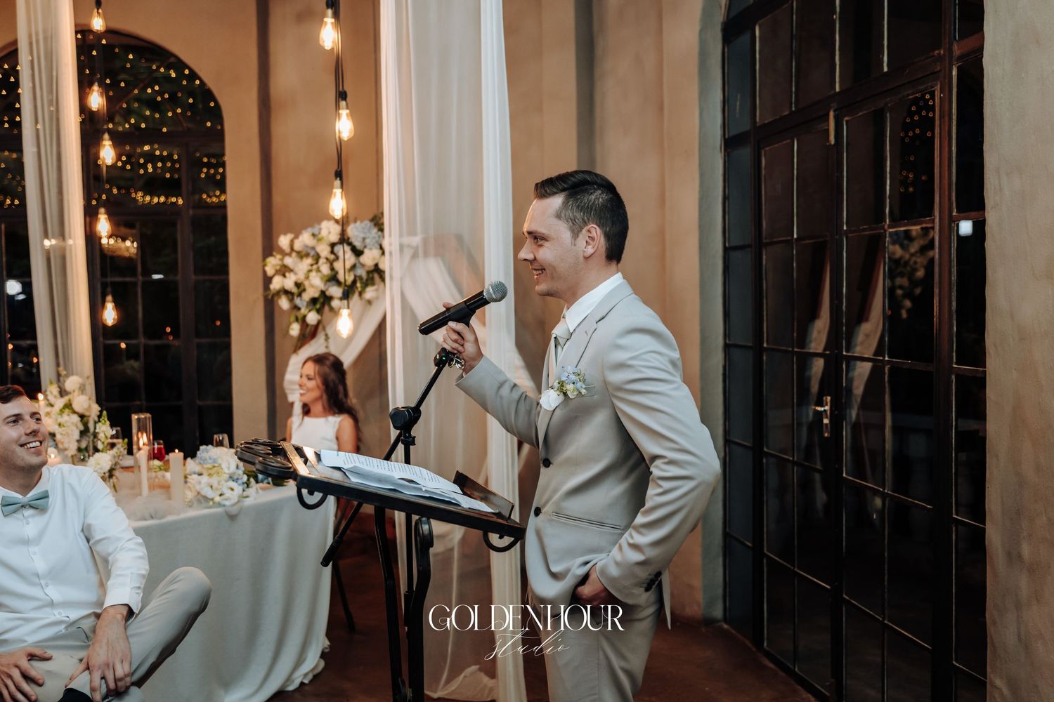 Indoor wedding venue with romantic string lights and elegant decor during evening celebration.