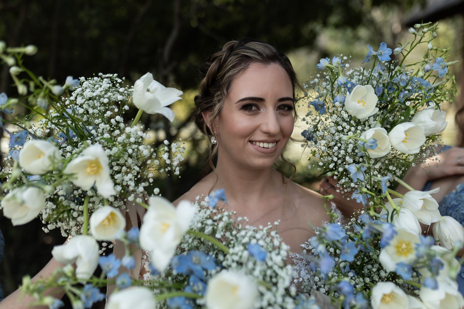 A bridal portrait surrounded by white calla lilies and baby's breath bouquets.