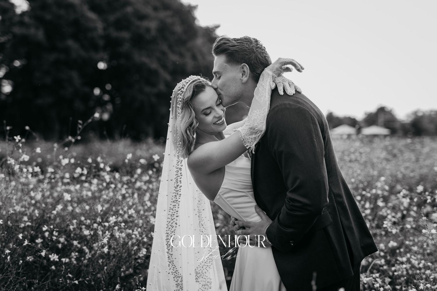 Romantic couple embracing in a wildflower field during their wedding photoshoot.