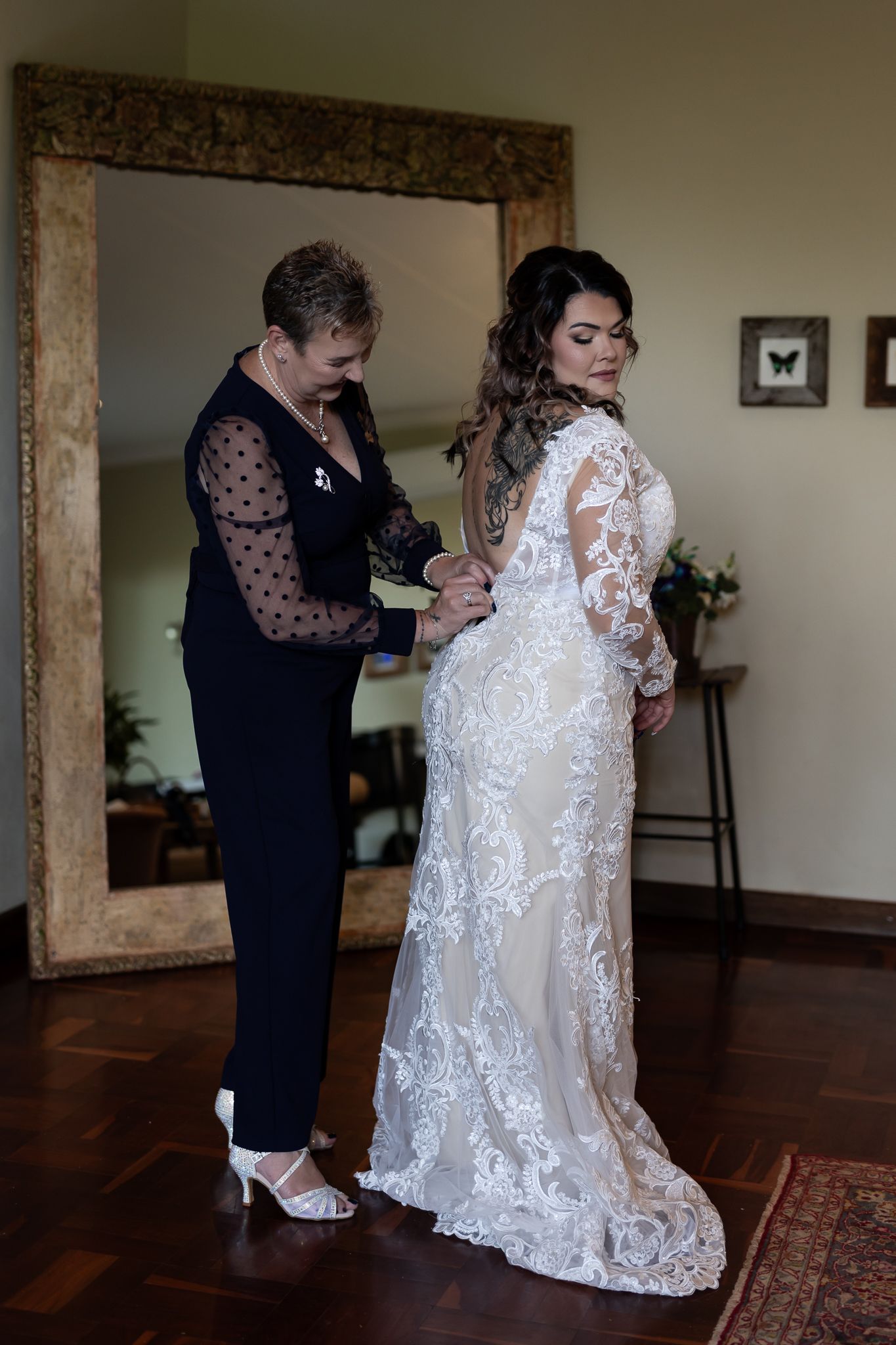 Final dress fitting moment with intricate lace wedding gown.