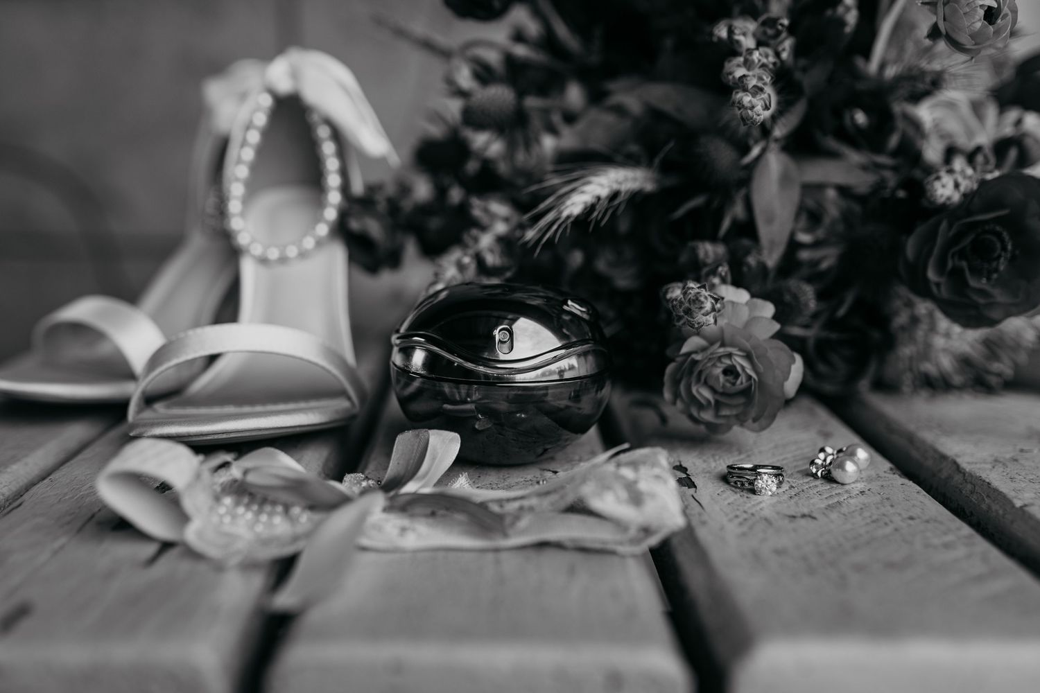 Wedding detail shot of shoes, sunglasses and floral elements in black and white.