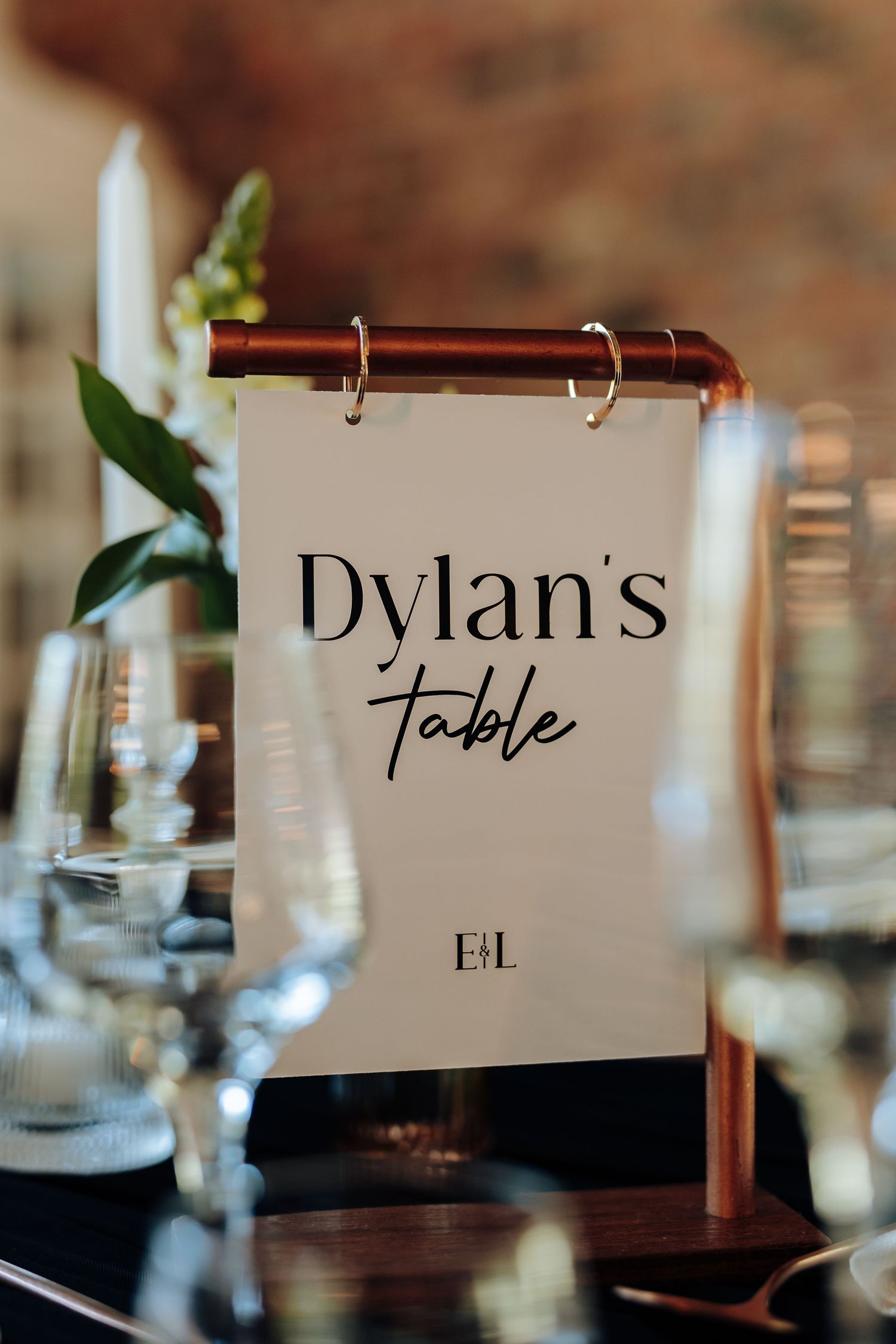 Wedding reception table signs with elegant typography displayed on wooden stands.